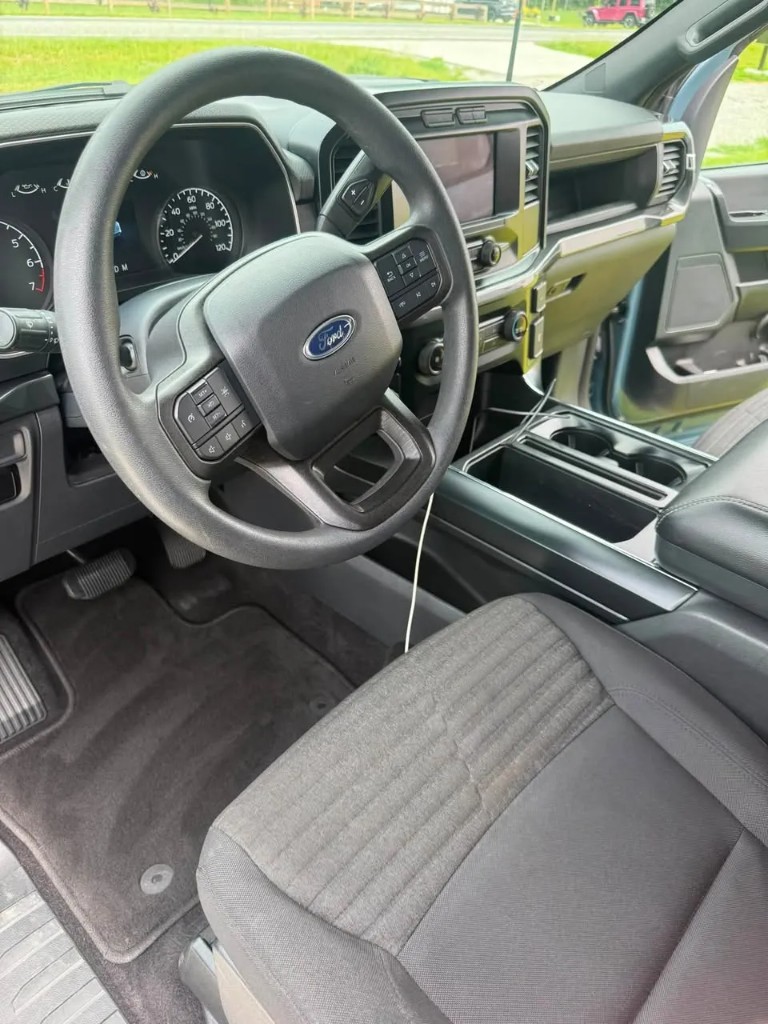 Detailed driver seat, floor mat, and steering area after vacuum and wipe-down